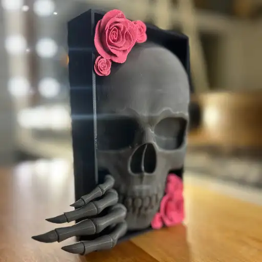 Kuru Kafa Kitap Tutucu - Huge 3D WORLD Kuru Kafa Kitap Tutucu – Dekoratif Kitaplık Düzeni Kuru Kafa Kitap Tutucu, kitaplarınızı düzenli tutarken aynı zamanda dekoratif bir obje olarak dikkat çeker. Sıra dışı ve cesur tasarımıyla kitaplığınıza bambaşka bir hava katarken, gotik dekor sevenler için ideal bir seçimdir. Kitapların devrilmesini önlerken güçlü görselliğiyle koleksiyonlarınıza estetik bir katkı sağlar. Ürünün detaylı işçiliği sayesinde, ışığın geliş açısına göre kuru kafa figürü üzerinde farklı tonlarda gölgeler ve parlak yansımalar oluşur. Bu etki, ürüne dinamik bir görünüm kazandırır ve bulunduğu ortama dramatik bir atmosfer katar. Hem evinizin farklı köşelerinde hem de ofis ortamında dikkat çekici bir dekoratif unsur olarak kullanılabilir. Özgün tasarımı sayesinde kitap severler ve koleksiyoncular için eşsiz bir hediye seçeneği de sunar. Kuru Kafa Kitap Tutucu Özellikleri Kuru kafa figürlü özgün tasarım Kuru Kafa Kitap Tutucu sağlam yapısıyla kitaplarınızı dik tutar Işığa bağlı olarak değişen gölge ve yansıma etkileri Gotik, modern ve alternatif dekorasyonlara uyumlu Dayanıklı malzemeden üretilmiştir Sevdikleriniz için sıra dışı bir hediye alternatifi Kuru Kafa Kitap Tutucu Nerelerde Kullanılır? Kuru Kafa Kitap Tutucu, salonunuzda ya da çalışma odanızda dikkat çekici bir dekoratif obje haline gelir. Kitaplık raflarında estetik bir düzenleyici, çalışma alanlarında karakterli bir aksesuar ya da salon dekorunda iddialı bir obje olarak kullanılabilir. Özellikle gotik, endüstriyel ve modern dekorasyon tarzlarını benimseyen mekanlarda öne çıkar. Koleksiyon figürleri, sanat eserleri veya mumluklarla birlikte sergilendiğinde dikkat çekici bir bütünlük oluşturur. Temizliği oldukça kolaydır; yumuşak ve kuru bir bezle silmek yeterlidir. Direkt ışık altında sergilendiğinde yansımaları daha belirgin hale gelir ve ürüne farklı bir boyut kazandırır. İlham ve Keşif Hem işlevsel hem estetik olan Kuru Kafa Kitap Tutucu, hediye alternatifi olarak da tercih edilebilir. Daha fazla dekoratif kitap tutucu ve 3D tasarım örneklerini görmek için My Work sayfamızı ziyaret edebilirsiniz. Ayrıca farklı mekanlarda kullanım önerileri ve güncel paylaşımlar için Instagram hesabımıza göz atabilirsiniz.