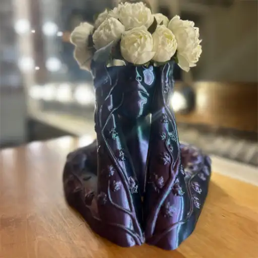 Sarmaşık Kadın Saksı – Sanatsal Ev Dekoru Sarmaşık Kadın Saksı, zarif dokusuyla çiçeklerin estetiğini heykel formunda yorumlar. Işığın geliş açısına göre yüzeyde görülen yeşil ve mor yansımalar, gün boyunca değişen bir derinlik sağlar ve bulunduğu ortama sofistike bir vurgu katar. Öne Çıkan Özellikler Kadın figürlü, heykelsi formda dekoratif saksı Işığa bağlı yeşil–mor renk değişimi ve canlı yansımalar Salon, çalışma odası ve antre gibi iç mekânlara uyum Sukulent, kaktüs ve küçük yapraklı bitkilerle dengeli görünüm Dengeli taban, kolay temizlenen yüzey ve uzun ömürlü kullanım Hediye etmeye uygun, koleksiyon değeri taşıyan tasarım Kullanım & Stil Önerileri Minimal aranjmanlarla modern, yoğun yeşil dokularla klasik bir atmosfer yaratabilirsiniz. Konsol, raf ya da pencere önünde tek parça odak olarak konumlandığında Sarmaşık Kadın Saksı mekânın karakterini belirginleştirir; açık ton bitkiler renk geçişlerini daha görünür kılar. Bakım ve Malzeme Yumuşak, kuru bir bezle nazikçe siliniz; sert kimyasallardan kaçınınız. Su taşmasını önlemek için iç saksı veya tabak kullanılması önerilir. Düzenli bakım, yüzey dokusunun ve ışık oyunlarının etkileyici görünümünü korur. Daha fazla dekoratif ürün görmek için Ürünlerimiz sayfamızı ziyaret edebilir, güncel paylaşımlar için Instagram hesabımıza göz atabilirsiniz.